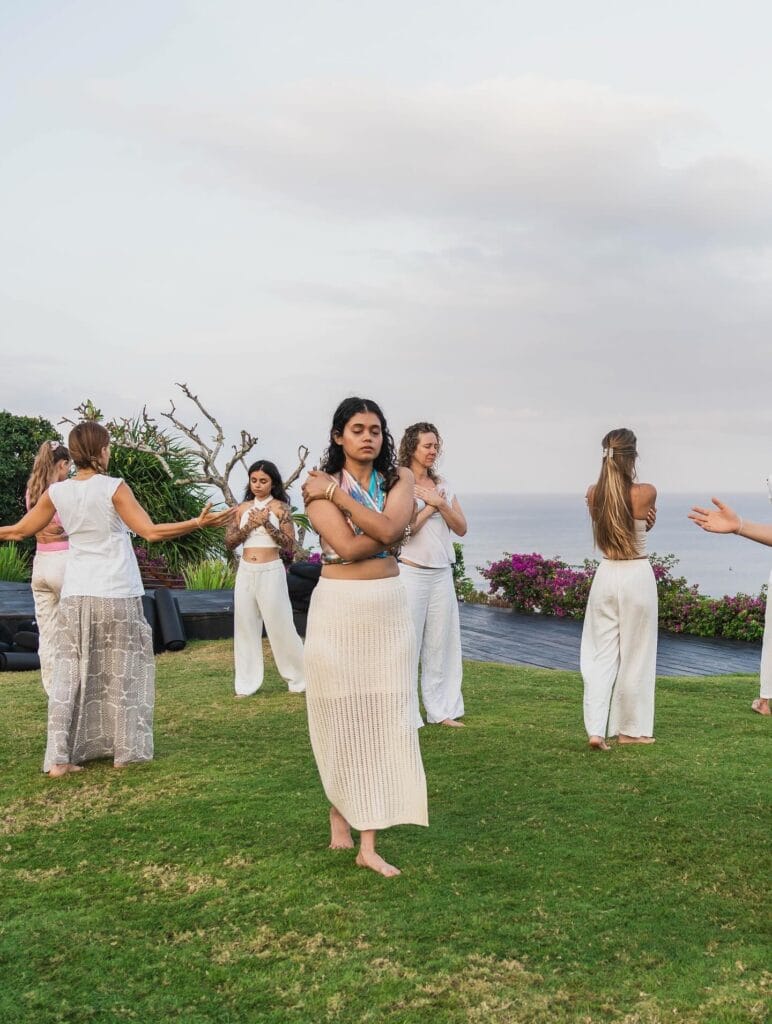 A group practising together on a lawn above the sea
